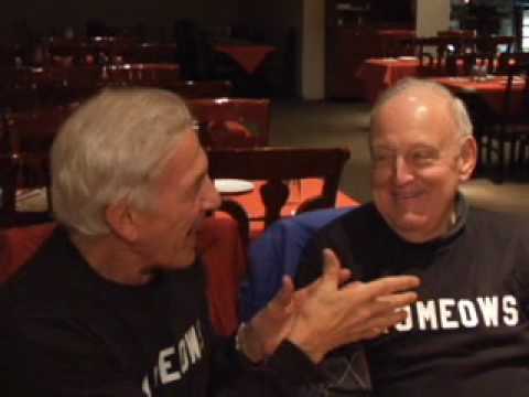 Two ROMEOWS members wearing their ROMEOWS t-shirts, laughing together at a restaurant